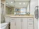 Bright bathroom features white cabinetry, stone countertop, mirrored wall, and a glass-enclosed shower at 1750 Benjamin Franklin Dr # 11G, Sarasota, FL 34236