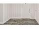 Condo hallway with neutral carpet, striped wallpaper, and white trim at 1750 Benjamin Franklin Dr # 11G, Sarasota, FL 34236