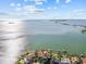 An aerial view captures a home with waterfront views, a private dock, and clear blue waters at 2402 Baywood W Dr, Dunedin, FL 34698