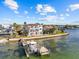 Stunning aerial view captures a waterfront estate with a boat dock and lush landscaping at 2402 Baywood W Dr, Dunedin, FL 34698