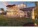 Beautiful backyard with lush lawn, fire pit, lounge chairs, and pergola creating a relaxing outdoor space at 2402 Baywood W Dr, Dunedin, FL 34698