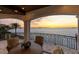 Charming balcony with wrought iron railings, comfortable seating, and panoramic waterfront views at sunset at 2402 Baywood W Dr, Dunedin, FL 34698