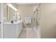 Neutral bathroom with white cabinets, granite counters, and glass door to the tub at 2402 Baywood W Dr, Dunedin, FL 34698