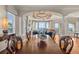 Spacious dining room with hardwood floors, elegant chandelier, and beautiful water views through large windows at 2402 Baywood W Dr, Dunedin, FL 34698
