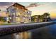 Elegant multi-story waterfront home with balconies, a pool, manicured lawn, and stunning water views at 2402 Baywood W Dr, Dunedin, FL 34698