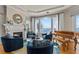 Cozy living room featuring a fireplace, comfortable seating, a piano, and panoramic water views at 2402 Baywood W Dr, Dunedin, FL 34698