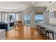 Open concept living space with waterfront views, a piano, a bar area, and access to a balcony at 2402 Baywood W Dr, Dunedin, FL 34698