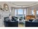 Bright living room featuring four comfortable armchairs, fireplace, and a large window overlooking the water at 2402 Baywood W Dr, Dunedin, FL 34698