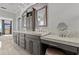 This luxurious main bathroom features dual vanities, granite countertops, custom cabinetry, and a makeup counter at 2402 Baywood W Dr, Dunedin, FL 34698