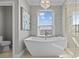 This modern main bathroom features a soaking tub, glass-enclosed shower, and elegant fixtures at 2402 Baywood W Dr, Dunedin, FL 34698