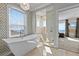 Relax in this spa-like main bathroom with a soaking tub, glass-enclosed shower, and stunning views at 2402 Baywood W Dr, Dunedin, FL 34698