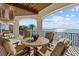 Relax on the patio with comfortable seating and enjoy the breathtaking panoramic waterfront views and a palm tree at 2402 Baywood W Dr, Dunedin, FL 34698