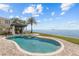 Enjoy waterfront views from this sparkling pool and spa, complemented by lush tropical landscaping at 2402 Baywood W Dr, Dunedin, FL 34698
