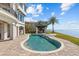 This beautiful swimming pool features an attached spa and patio, overlooking the water at 2402 Baywood W Dr, Dunedin, FL 34698