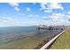 Expansive water view highlighting the shoreline, pier, and boats docked with cloudy skies overhead at 2402 Baywood W Dr, Dunedin, FL 34698