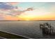 Picturesque sunset view over the water featuring a private boat dock, creating a serene and peaceful ambiance at 2402 Baywood W Dr, Dunedin, FL 34698