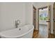 Stylish bathroom with a freestanding tub, wood floors, and open doorway to another room at 2444 Jacobs St, Port Charlotte, FL 33953