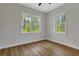 Bright bedroom featuring wood-look flooring, a ceiling fan and two large windows at 2444 Jacobs St, Port Charlotte, FL 33953