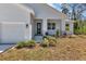 Inviting front entrance with a modern door, well manicured landscape, and covered porch at 2444 Jacobs St, Port Charlotte, FL 33953