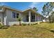 Rear exterior of home with covered patio and landscaped yard in sunny backyard at 2444 Jacobs St, Port Charlotte, FL 33953