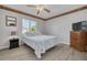 Bright bedroom with seashell patterned bedding, ceiling fan, and wood-look flooring at 2605 Fulton Sw St, Largo, FL 33774