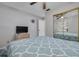 Bedroom with a patterned bedspread, ceiling fan, and mirrored closet doors at 2605 Fulton Sw St, Largo, FL 33774