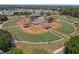 Aerial view of a well-maintained baseball field surrounded by lush greenery and clear skies at 2782 Countryside Blvd # 2, Clearwater, FL 33761