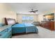 Spacious bedroom featuring a large bed, dresser, ceiling fan, and a picturesque window view at 2782 Countryside Blvd # 2, Clearwater, FL 33761