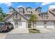 A close-up of the townhouse exteriors, each featuring a two-car garage and a well-manicured lawn at 2782 Countryside Blvd # 2, Clearwater, FL 33761