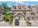 A charming townhouse showcasing an exterior elevation, featuring a two-car garage, balcony and picturesque lake views at 2782 Countryside Blvd # 2, Clearwater, FL 33761