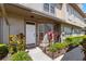 A pristine white front door is framed by flourishing plants and thoughtful exterior accents at 2782 Countryside Blvd # 2, Clearwater, FL 33761