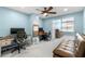 Home office with dual desks, multiple monitors, ceiling fan, and a cozy seating area at 2782 Countryside Blvd # 2, Clearwater, FL 33761