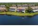 A serene view from the water of the rear townhouse exteriors, showcasing screened-in patios and green lawns at 2782 Countryside Blvd # 2, Clearwater, FL 33761