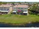 Back of home featuring screened enclosures, lawn, and pond views at 2782 Countryside Blvd # 2, Clearwater, FL 33761