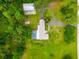 Aerial view of a house with a pool and barn in a lush green, wooded area at 28628 Bennington Dr, Wesley Chapel, FL 33544