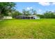 Expansive backyard featuring lush green grass, large screened-in pool, and ample space at 28628 Bennington Dr, Wesley Chapel, FL 33544