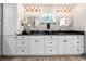 Bathroom with double vanity, black countertop and white cabinets at 28628 Bennington Dr, Wesley Chapel, FL 33544