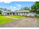 Beautiful home with gray siding, stone accents, a well-manicured lawn, and a paved driveway at 28628 Bennington Dr, Wesley Chapel, FL 33544