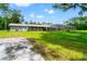 Backyard exterior view of the home, showcasing the screened-in patio and vast, lush lawn at 28628 Bennington Dr, Wesley Chapel, FL 33544