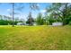 A sprawling property with a house, detached garage, and expansive green space surrounded by trees at 28628 Bennington Dr, Wesley Chapel, FL 33544