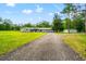 Well-kept home featuring a long driveway, detached garage, and large front yard with mature trees at 28628 Bennington Dr, Wesley Chapel, FL 33544