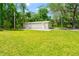 Side view of large garage and storage building in the backyard surrounded by greenery at 28628 Bennington Dr, Wesley Chapel, FL 33544