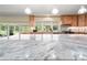 Bright kitchen island with light countertops, wood cabinetry and views of the lanai at 28628 Bennington Dr, Wesley Chapel, FL 33544