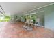Covered patio with brick pavers, seating area, and tranquil backyard view at 28628 Bennington Dr, Wesley Chapel, FL 33544