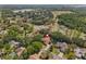 Aerial view of a neighborhood with a home marked by a pin, near a lake and golf course, surrounded by lush trees at 3022 Forest Club Dr, Plant City, FL 33566