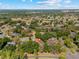 Aerial view of a property marked with a pin, showcasing the surrounding neighborhood with lush greenery and a golf course at 3022 Forest Club Dr, Plant City, FL 33566