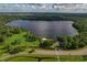 An aerial view showcases a serene lake community surrounded by lush trees and scenic parks at 3022 Forest Club Dr, Plant City, FL 33566
