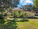 Beautiful home with lush landscaping, mature trees, and a manicured lawn creating a picturesque and inviting exterior at 3022 Forest Club Dr, Plant City, FL 33566