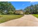 Inviting home showcasing a concrete driveway, manicured lawn, and mature landscaping, set under a clear blue sky at 3022 Forest Club Dr, Plant City, FL 33566