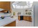 An open concept kitchen with white appliances, wood cabinets, and large windows at 3022 Forest Club Dr, Plant City, FL 33566